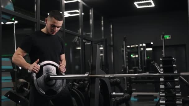 杠铃运动 健身目标 肌肉滋润 男人通过在健身房增加重量来准备自己的杠铃 — 图库视频影像