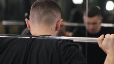 Çömelme tekniği, bacak egzersizleri, kas gelişimleri. Vücut geliştirici, ağırlıkları boynuna yerleştirilmiş halterlerle halter çökerterek, sağlıklı yaşam tarzına olan bağlılığını somutlaştırarak aşırı erkeksi bir güç gösterir.