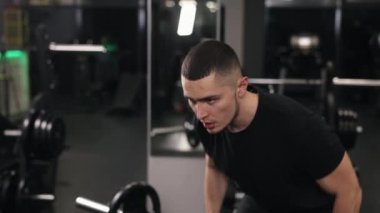 Formda kalma, kilo sorunları, güvenlik önlemleri. Vücut geliştirmeye güçlü bağlılığıyla, adam ağırlık kaldırıyor, fitness hedeflerine ulaşmaya kararlı ve etkileyici kas gücünü sergiliyor.