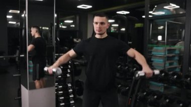 Fitness özverisi, antrenman tutarlılığı, spor salonu rutini. İşlevsel eğitim için halterleri kullanan zinde insan, egzersiz talimlerine katılarak gücünü ve kararlılığını gösterir.