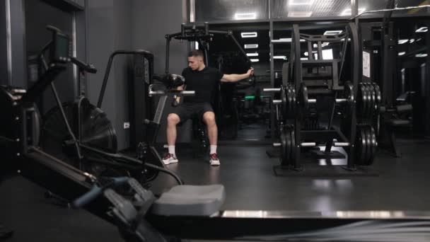 体形匀称 动作匀称 在体育馆里 用专门的机器进行食欲强 体格健康的男人紧张地锻炼手臂和胸部肌肉 — 图库视频影像
