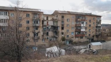 Yanan evler, yıkılan binalar, hasar gören füzeler. Felaketin ortasında yıkılmış bir bina. Enkaz, toz ve hasarlı ev seli var. Ukrayna 'daki bombalama sonrası.