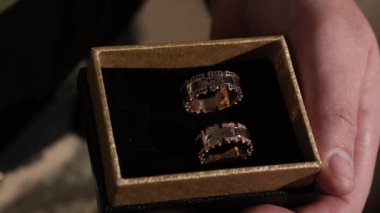 Askeri teklif, askerlik görevi, düğün kıyafeti. Savaş gazisi yüzükleri elinde tutuyor ve sevgilisine evlenme teklif etmek üzere..