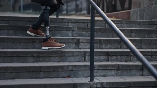 適応階段クライミング 手足の交換 クライミングの多様性 市内の階段は義足の男が登り障害者です — ストック動画