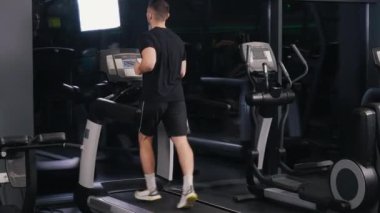 Erkek atletik, genç erkek, koşu bandı. Genç erkek spor salonunda spor yapıyor, koşu bandında koşuyor..