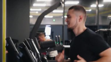 Jimnastik aktiviteleri, spor salonu, koşu bandı. Spor meraklısı gençler spor salonunda koşu bandında koşuyor..