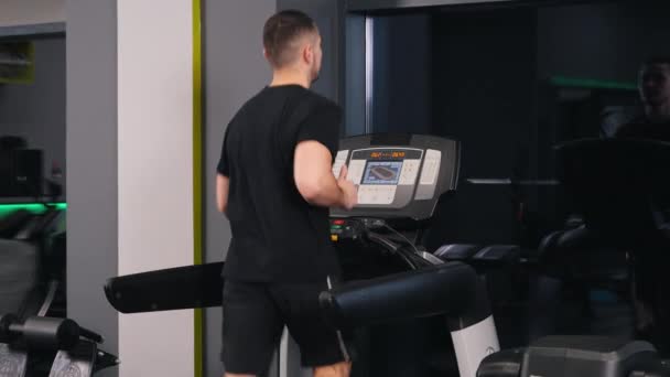 트레드밀 체육관에서 남자가 머신에서 조깅하면서 스포츠 활동을 — 비디오