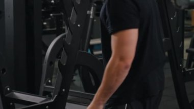 Salon yukarı, ağırlık yukarı, halter yukarı. Spor salonundaki adam halterini ek ağırlıklarla yapılandırıyor..