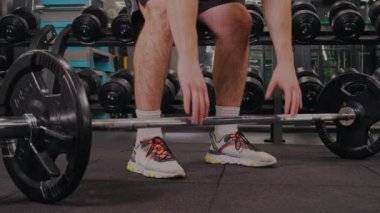 Halter kararlılığı, fitness amaçları, halter eğitimi. Vücut geliştirme için sarsılmaz bir adanmışlık sergileyen adam halter ağırlıklarını kaldırır, fitness hedeflerine ulaşmaya karar verir.