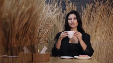 Kafe rahatlaması, kahve deneyimi, içecek molası. Güzel bayan lokantada kahve içiyor..