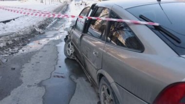 Bariyer bandı, sokakta kaza, çalıntı araba. Ön tarafı kazayla ezilen araba, dikkat bandıyla çitle çevrilmiş..