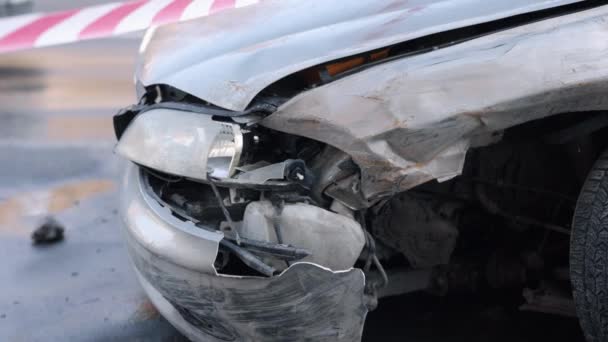 事故の後 衝突被害 車の残骸 事故で大きく損傷したフロントでは 自動車は慎重にテープでマークオフ — ストック動画