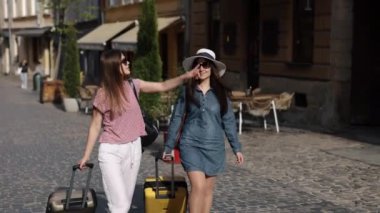 Valizlerle yürüyüş, şehir sokakları, gezgin kadın. Birkaç güzel kadın turist ellerinde bavullarıyla caddede geziniyor ve yabancı maceralarından zevk alıyorlar..