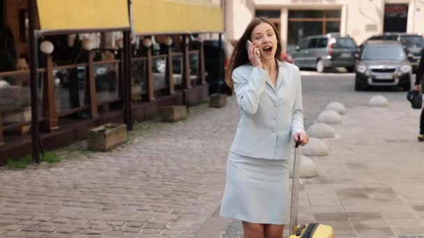 電話で話すビジネスマン 携帯電話で話す プロの散歩 ビジネスマンの女性は電話会話をしながら道路を歩いている — ストック動画