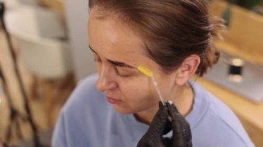 Mükemmel makyaj, kaplama prosedürü, kaş makyajı. Güzellik salonunda kaş düzeltme tedavisi gören genç bir kadın var. Kaşları mikro bıçaklı, boyalı kaşları boyalı.