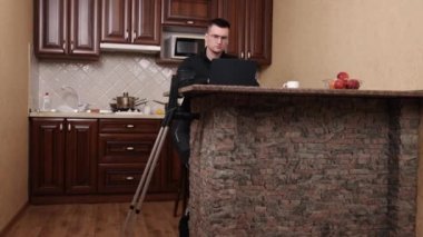 Koltuk değnekleri yakında, sakatlık dahil, protez teknoloji. Bacak protezi takan gözlüklü adam yanında dizüstü bilgisayarı koltuk değneği olarak kullanıyor..