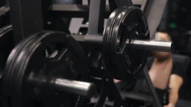 Erkek antrenör, spor hocası, bacak kaslarını hedef alıyor. Çekici erkek antrenör jimnastik salonu bacak egzersizleri yapıyor..