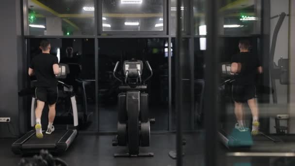 间歇训练 健身跟踪器 体操跑步机 这个人正在用跑步机来实现他的健身目标 — 图库视频影像