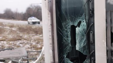 Kırık ön cam, yanıp sönen ışıklar, polis ışıkları. Kazaya karıştıktan sonra, kamyonun ön camı kırıldı ve polis arabasıyla birlikte yol kenarında parlayan ışıklarla yatıyor.