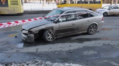Çarpışan araba, uyarı bandı, hasarlı araç. Otomobil, kazadan dolayı parçalanan ön kısım, uyarı bandıyla işaretlenmiş..