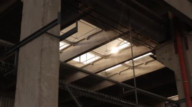 Tavan penceresi, fabrika ışıkları, termal performans. Duvarlar endüstriyel yapı, güneş ışığını tavan penceresinden içeri akarken yıkıyor..