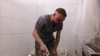 Su karışımı, alçı karışımı, su modeli. Adam alçı modelini hazırlıyor ve suya alçı ekliyor..