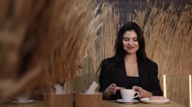 Restoran sahnesi, kafe güzelliği, kafe zarafeti. Lokantada zarif bir kadın kahvesinden zevk alır..