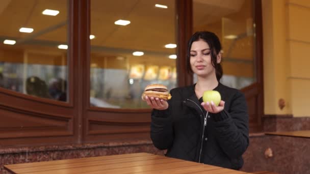 汉堡拒绝 均衡膳食 苹果的胜利 女人在做出健康的选择时 选择苹果而不是吃汉堡包 — 图库视频影像