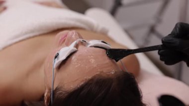 Spatül, epilasyon jeli, kadın müşteri. Steril eldivenli kozmetolog, epilasyondan önce kadınlara ultrason jeli uyguluyor, Esthetisyenler kadın derisini lazer tüy aldırmaya hazırlıyorlar.