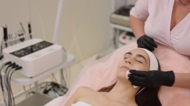 Temizleme çözeltisi, yüz temizleme, güzellik uzmanı temizliği. Deri uzmanı, cilt rengini nazikçe temizleyiciye batırılmış peçeteyi yüzüne sürterek temizliyor..