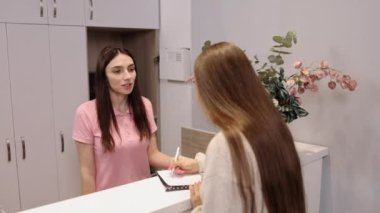 Lobi selamı, hoş geldin masası, ofis formları. Takım üyesi müşteriyi girişte karşılar ve doldurulması gereken anketi sağlar.