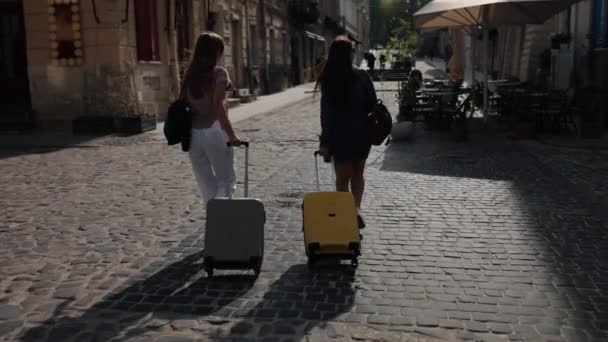 旅行概念 街头探险 旅游旅行 两个愉快的女游手好闲的人带着行李在城市的道路上漫游 享受着海外旅行的乐趣 — 图库视频影像