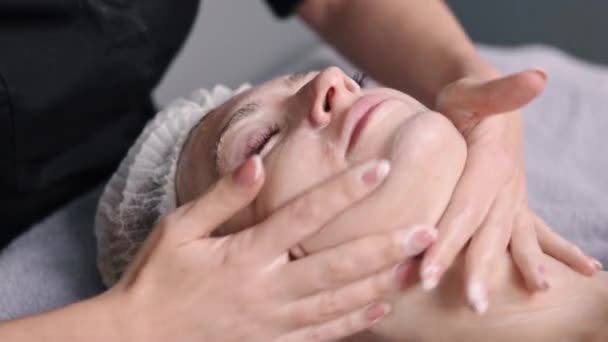 美容院 美容美发霜 美容师护理 美容院的病人正在接受护肤霜的治疗 并由熟练的美容师按摩 — 图库视频影像