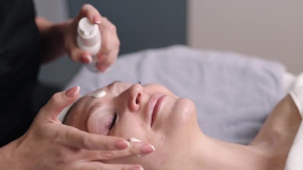 采购产品防晒霜 Spf化妆品 皮肤健康 美容师将Spf防晒霜涂在客户脸上 — 图库视频影像
