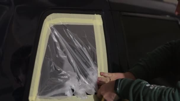 テープ 使用ツール ペイントアプリケーションを使用しています 塗料の新鮮なコートの前に サンドダウン車をカバーするために紙を使用して整備士 — ストック動画