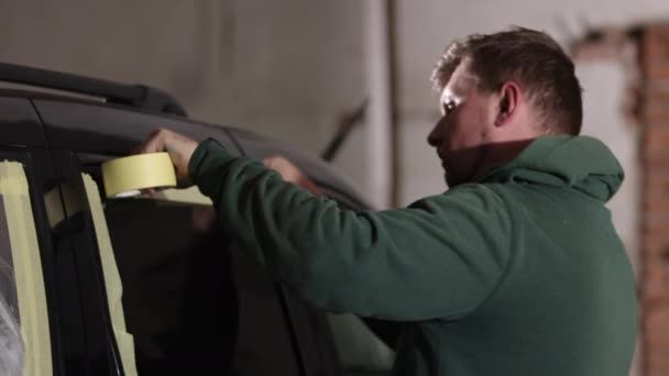 マスクプロセス 手順ガイド プロフェッショナルメソッド 塗装する前に車に紙を確保する自動車労働者 — ストック動画