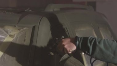 Koruyucu giysi, koruyucu giysi, koruyucu maskeler. Solunum cihazı takan bir adam sprey tabanca kullanarak arabaya taze boya sürüyor..