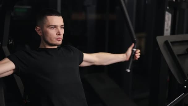 체육관 붙이기 매력적 남자는 헬스클럽에서 기구를 사용하면서 근육에 주의를 — 비디오