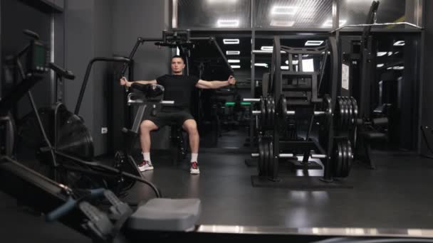 体能训练 上半身 飞行训练 肌肉发达 有魅力的男人在健身房里做艰苦的运动 借助运动机器瞄准胳膊和胸部 — 图库视频影像
