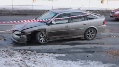 Bariyer bandı, sokakta kaza, araba kazası. Araç, çarpışmadan sonra ağır hasar görmüş, acil durum bandıyla kapatılmış..
