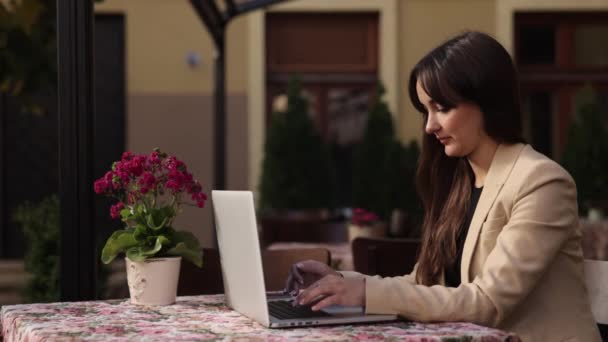 外のオフィスノートパソコンのメールテキストメッセージ ビジネスの女性は 彼女のキーボードで作業し 外のノートパソコンに入力し かなりブルネットの女性が電子メールを入力し ノートパソコンで作業してコンピュータにブログを書く — ストック動画