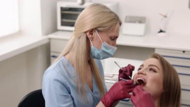 Caries treatment, Dental check-up, Cavity treatment. In effort to safeguard dental health, doctor scrutinizes oral cavity for tooth decay while focusing on caries prevention and cure.