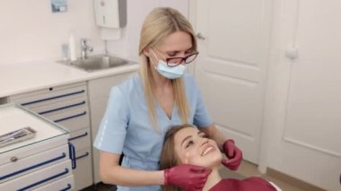 Orthodontic examination, Dental checkup, Patient examination. Female patients jaw joints are being physically examined by doctor trained in orthodontics and gnathology.