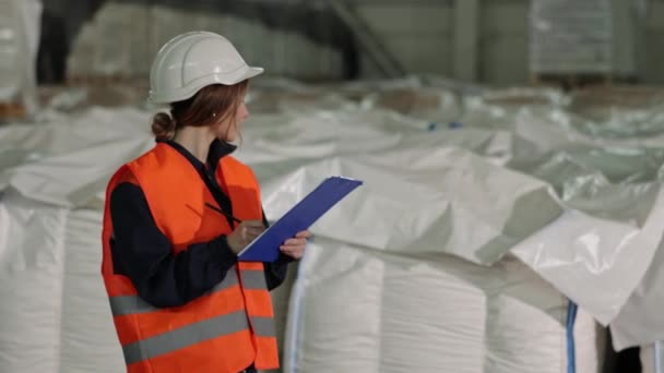 袋のカウント 工場プロダクト 袋の点検 工場の女性検査官が製品監査を監督し 白い袋を数え 必要な表記をする — ストック動画