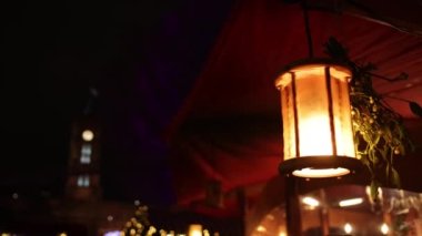 Açık havada aydınlatma, Noel Xmas 'ın akşamları aydınlatma, parlak akkor lambalar çelenk gibi kablolardan asılı vitrinlere, bir çelenkten arka plan, karanlıkta yanan lambalar.