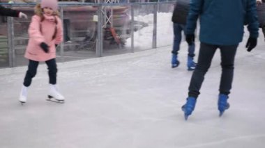 BERLİN, ALMANY - 26 ARALIK 2021: Buz pateni pisti, çocuklu vatandaşlar, kış eğlencesi. Kışın buz pateni pistinde kayan insanlar, eğlence, tatil, Berlin 'de kış aylarında buz pateni pistinde Noel pazarı