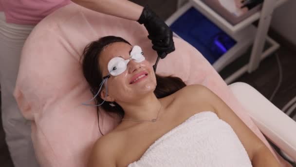 激光消融 应用凝胶 一次性唾液 美容师在美容外科诊所为女性皮肤进行激光脱毛治疗 美容师对女性进行激光脱毛治疗 — 图库视频影像