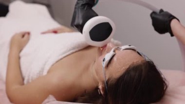 Saç aldırma, kozmetoloji prosedürü, lazer gençleştirme. Lazer epilasyon ve kozmetoloji, saç temizleme yöntemleri uygulanır, kozmetoloji ve spa kavramları temsil edilir, genç kadının düşük kesimi