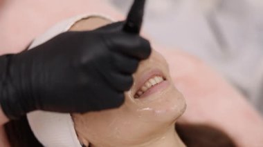 Güzellik hizmetleri, tedavi sıklığı, güzellik trendleri. Güzellik danışmanı, radyo frekans kaldırma olarak bilinen RF kaldırma tedavisini hasta üzerinde gerçekleştiriyor..