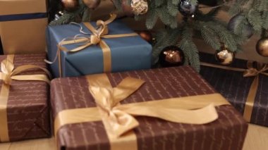 Yeni yıl, Noel hediyesi, köknar ağacı. Noel hediye kutuları, kurdele ve süslemelerle bağlanmış, Noel arkaplanı, yerdeki köknar ağacının yanında duran güzel Noel hediye kutuları,
